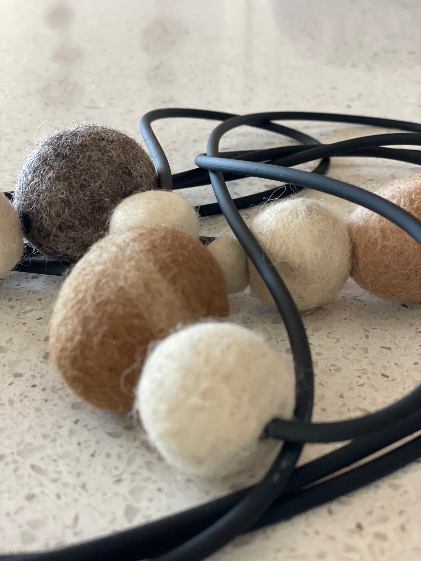 Modern Long Triple Strand Black Rubber Necklace With 7 Neutral-Color Wool Felt Balls